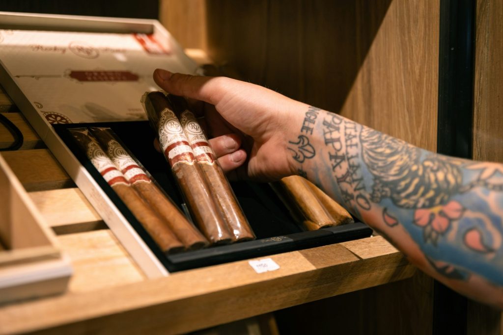 A person holding a box of cigars in their hand
